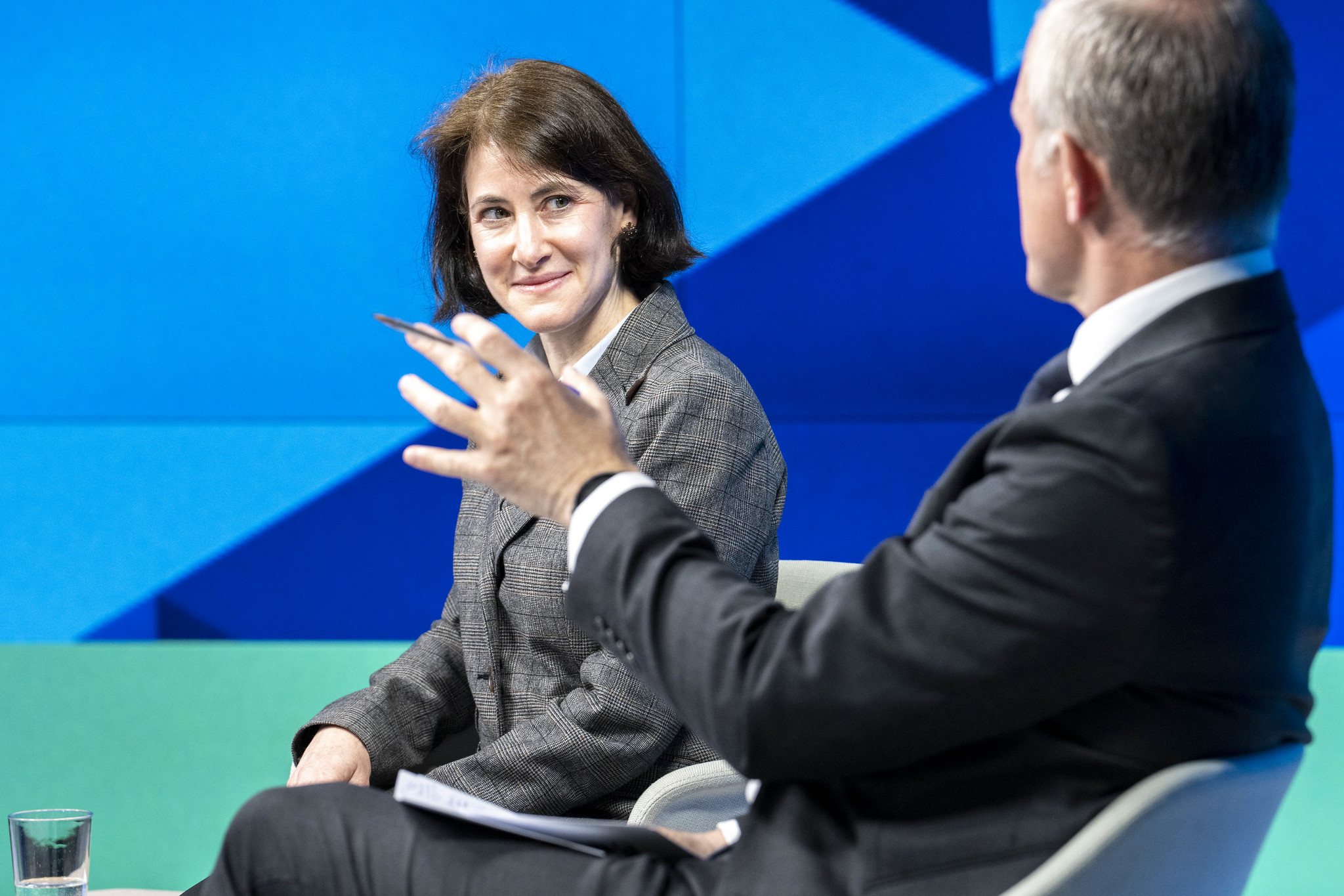 A woman on stage looking a man talking